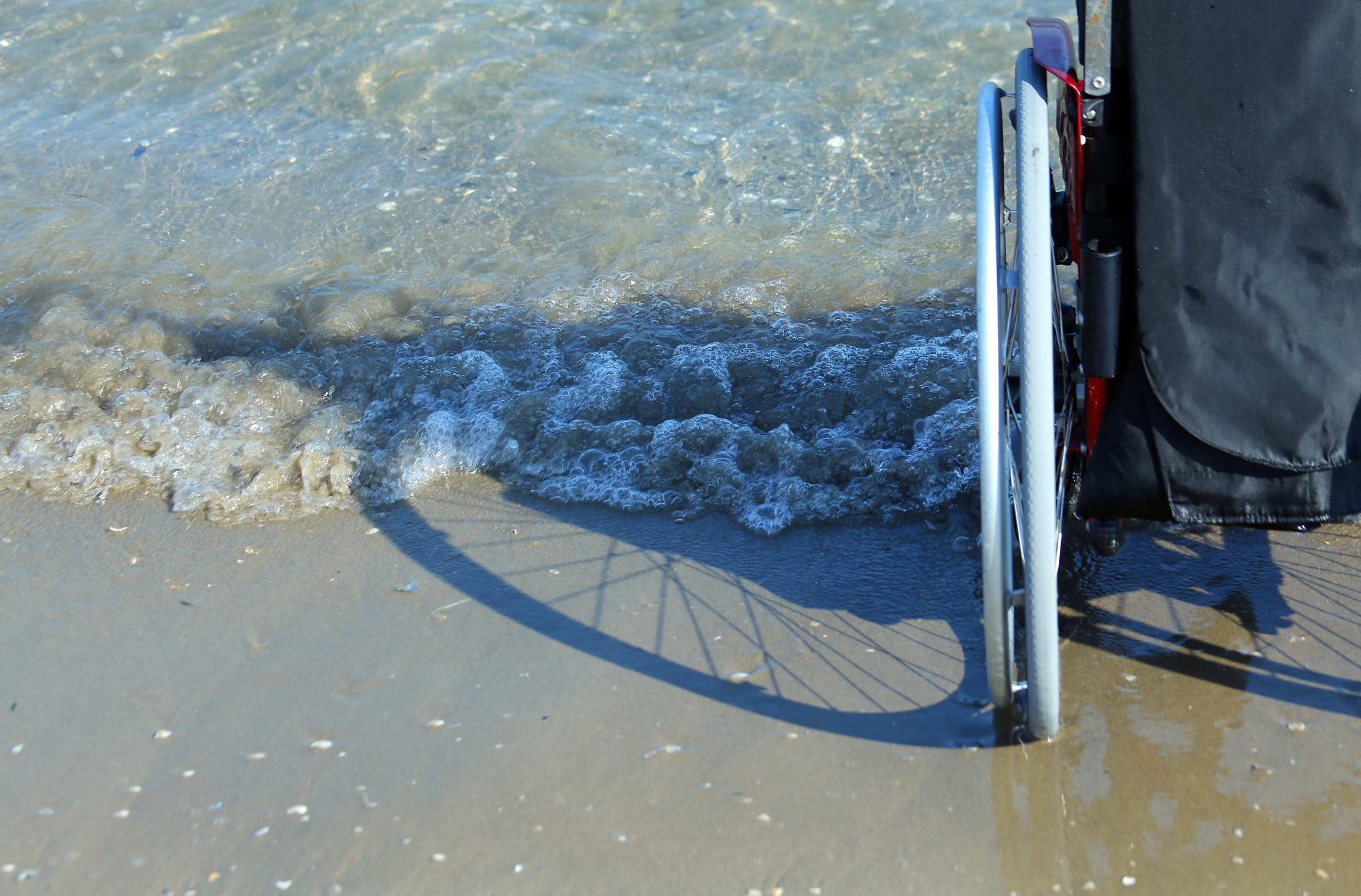 shadow of a wheelchair in the sand on the seashore